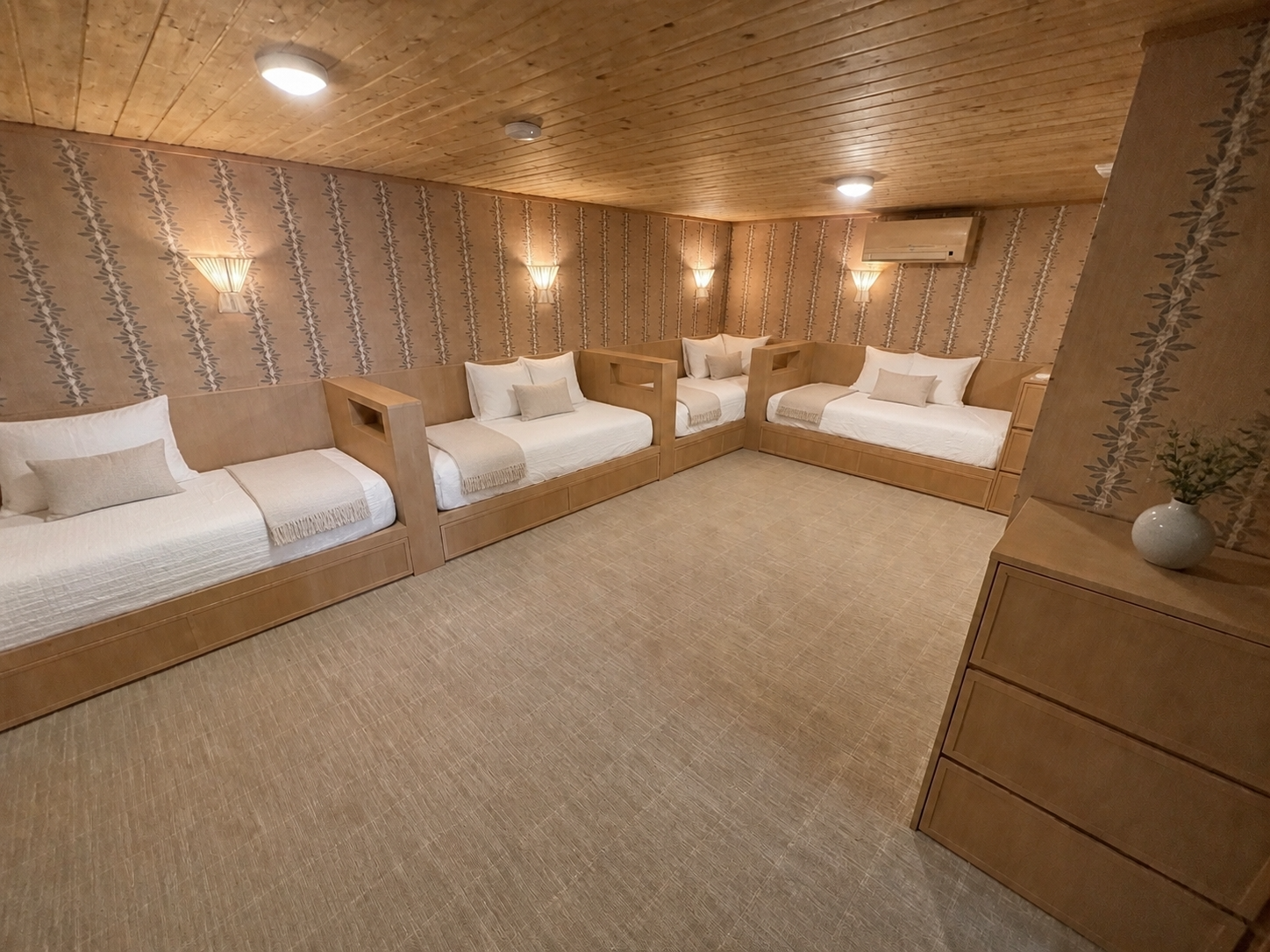 Custom bunk room with four built-in wood beds, integrated storage, botanical wallpaper, and a timber ceiling