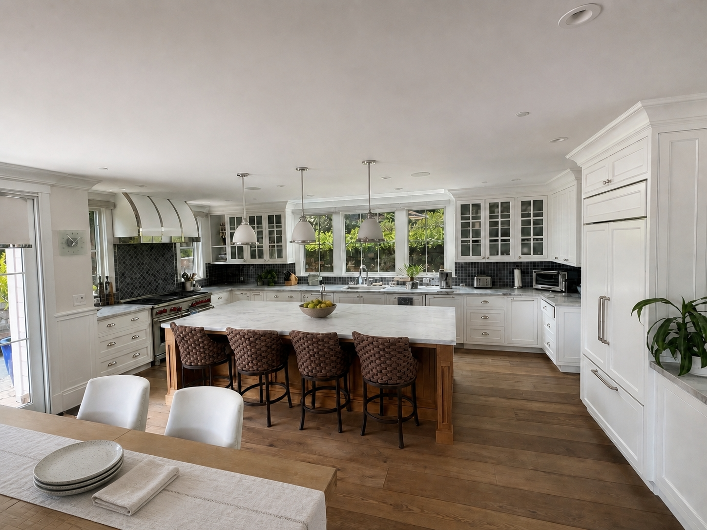 White kitchen with glass-front cabinetry, a marble-topped island, pendant lights, and wide-plank wood floors